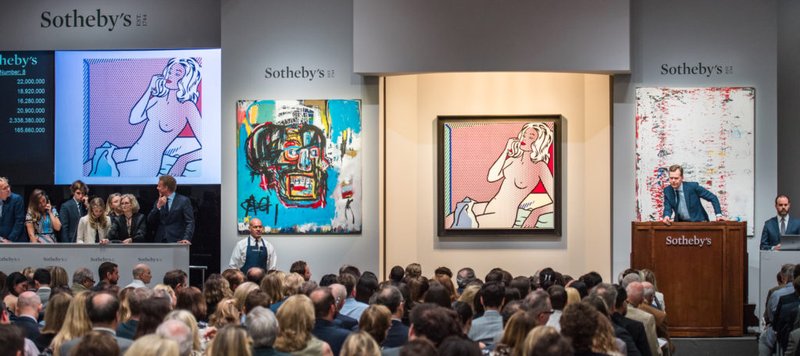 Art auction in progress with bidders and auctioneer